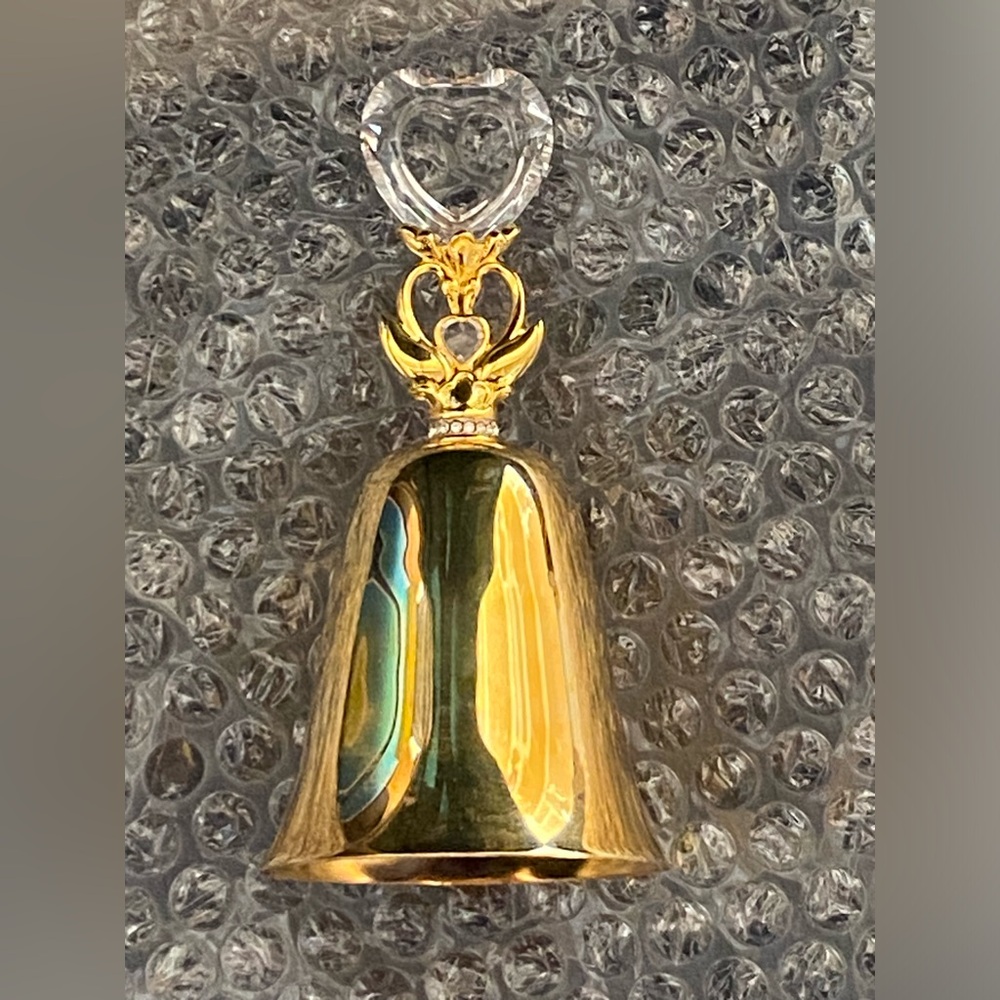 Gold-plated hand bell features a distinctive clear crystal heart-shaped handle
